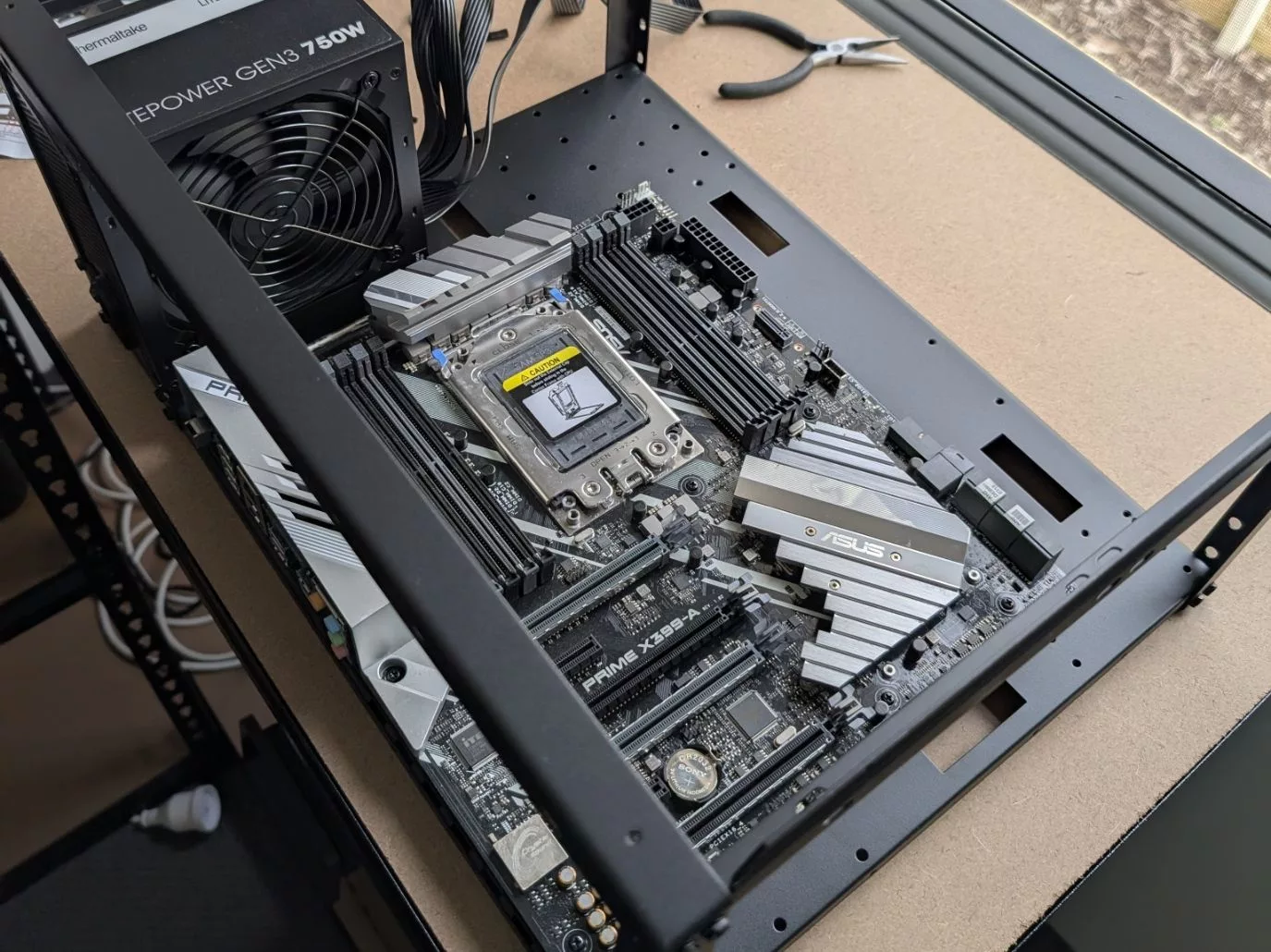 ASUS PRIME X399-A motherboard with a Threadripper installed in an open steel frame next to a power supply